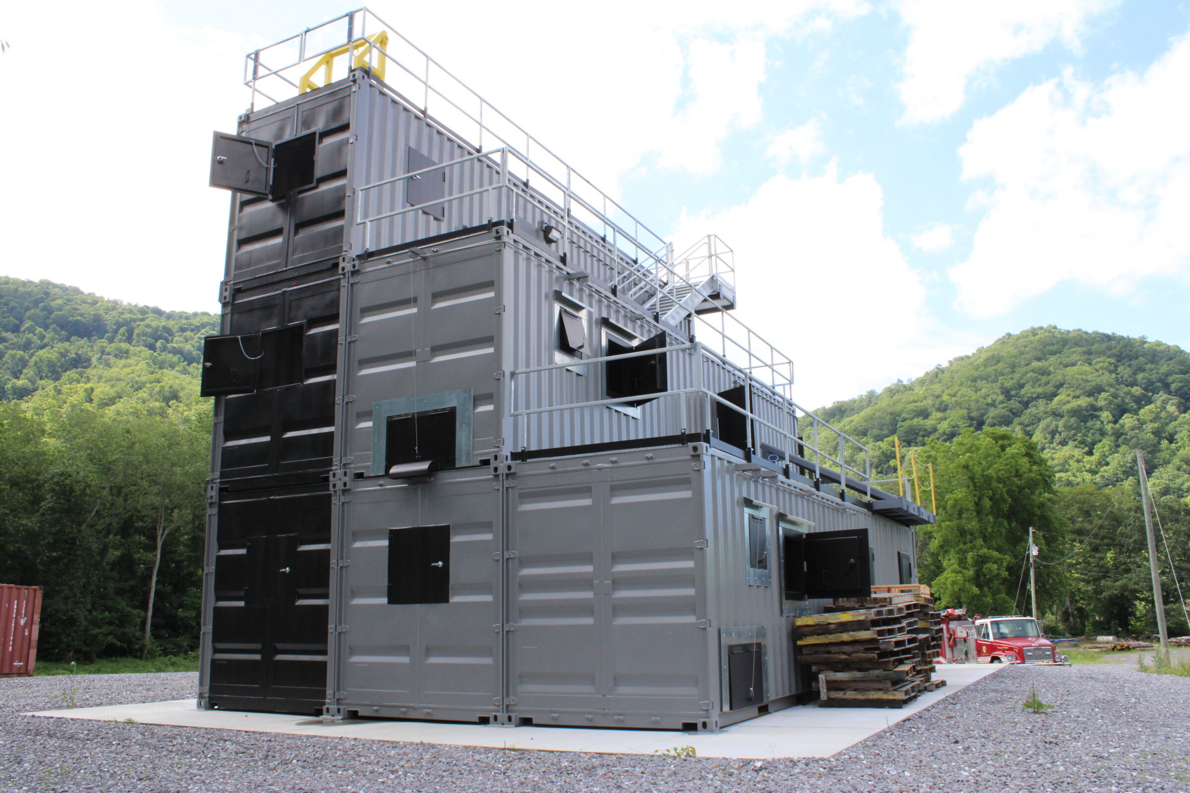 Newdale Anvil live burn fire training structure built from stacked steel containers with multiple training levels and exterior walkways.